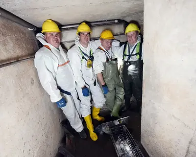 Mitarbeiter SWM Bereich Abwasser stehen im Kanal vier Mitarbeiter von SWM aus dem Bereich Abwasser stehen im Abwasser-Kanal